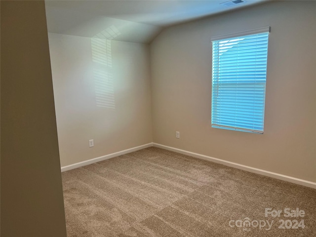 empty room featuring carpet and lofted ceiling