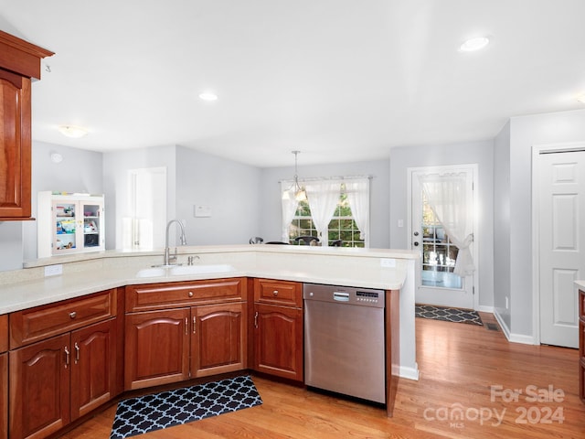 kitchen with sink, stainless steel dishwasher, decorative light fixtures, and light hardwood / wood-style floors