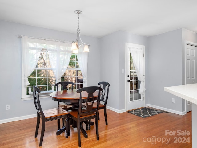 dining area with wood-type flooring and a notable chandelier