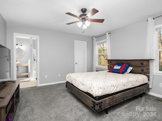 bedroom featuring carpet, a textured ceiling, ensuite bath, and ceiling fan