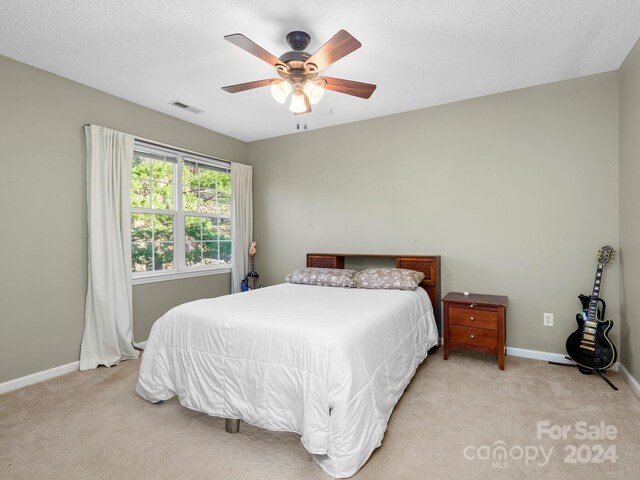 carpeted bedroom featuring a textured ceiling and ceiling fan