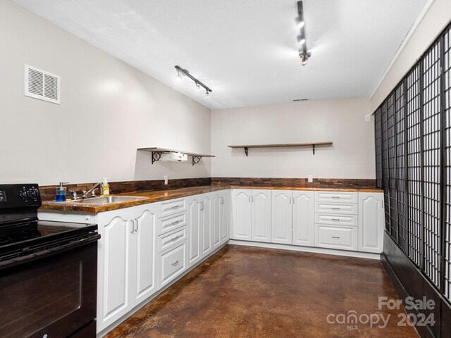 kitchen featuring white cabinetry, sink, rail lighting, and black range with electric cooktop