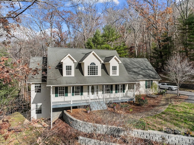 cape cod home featuring covered porch