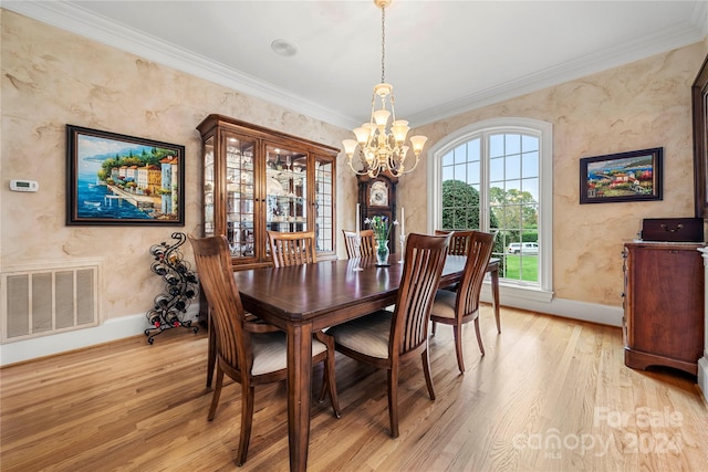 dining area with a notable chandelier, light wood-type flooring, and crown molding