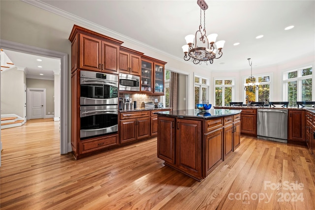 kitchen featuring light hardwood / wood-style flooring, a chandelier, decorative light fixtures, and appliances with stainless steel finishes