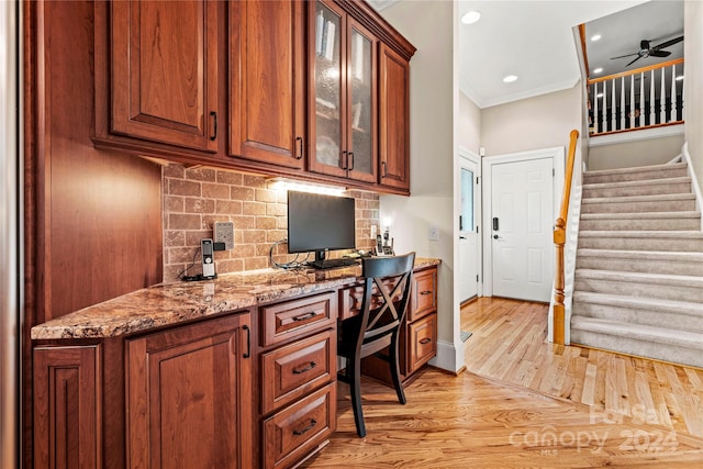 office with built in desk, light hardwood / wood-style floors, ceiling fan, and ornamental molding