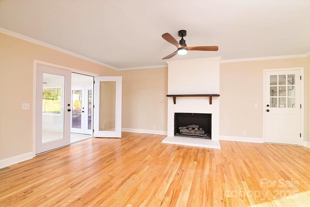 unfurnished living room featuring french doors, ceiling fan, light hardwood / wood-style floors, a brick fireplace, and crown molding