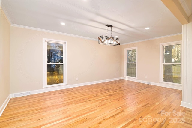 unfurnished dining area featuring an inviting chandelier, crown molding, and light hardwood / wood-style flooring