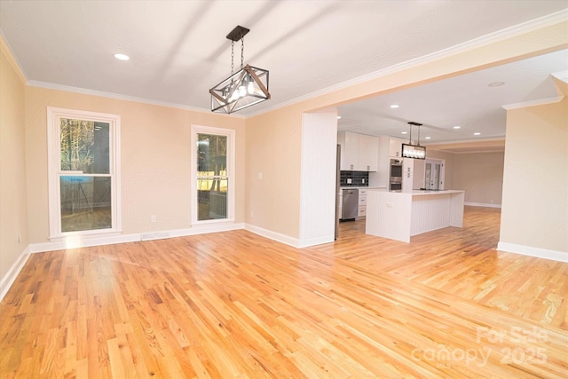 unfurnished living room featuring a notable chandelier, crown molding, and light hardwood / wood-style flooring