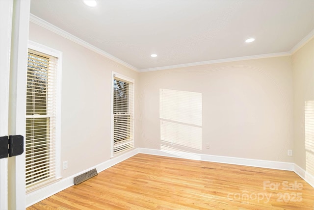 spare room featuring wood-type flooring and ornamental molding