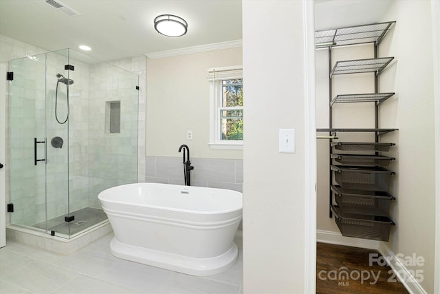 bathroom with wood-type flooring, crown molding, and independent shower and bath