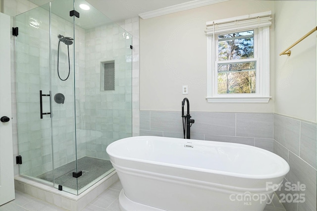 bathroom with separate shower and tub, tile walls, tile patterned floors, and ornamental molding