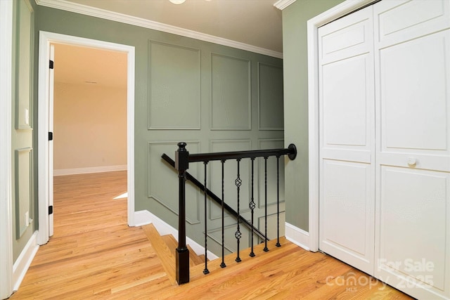 corridor featuring ornamental molding and light hardwood / wood-style floors