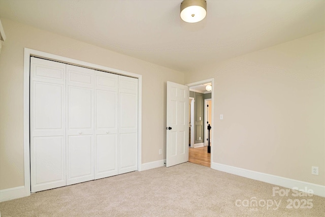 unfurnished bedroom with a closet and light carpet