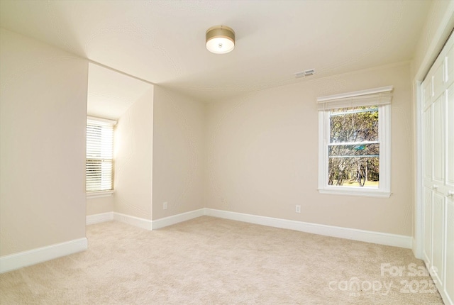 unfurnished room featuring light carpet