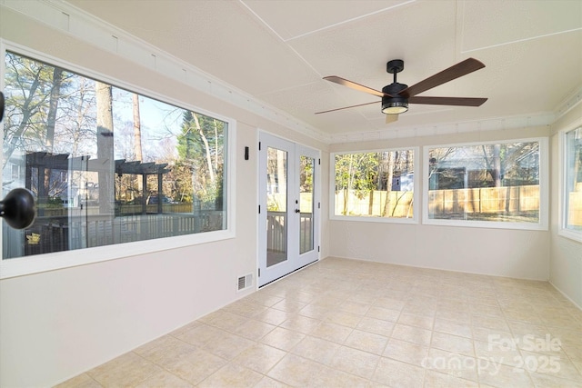 unfurnished sunroom featuring ceiling fan and french doors