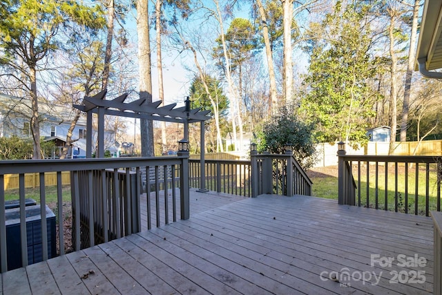 deck featuring a pergola and a yard