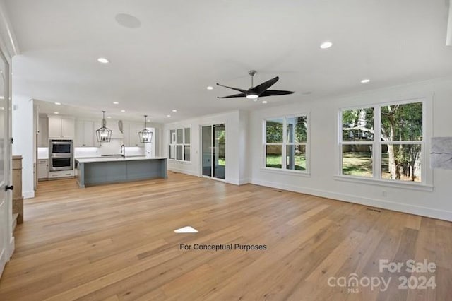 unfurnished living room featuring ceiling fan and light hardwood / wood-style floors