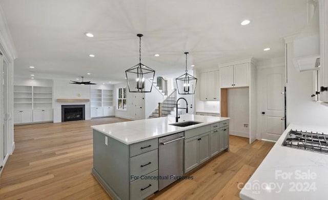 kitchen featuring sink, light wood-type flooring, a center island with sink, and appliances with stainless steel finishes