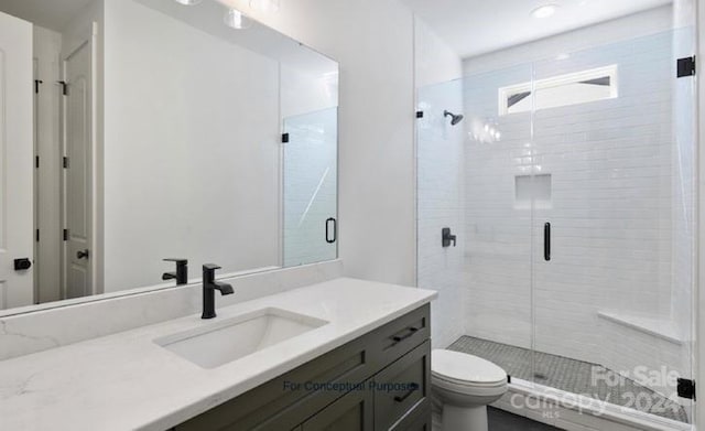 bathroom with toilet, vanity, and walk in shower