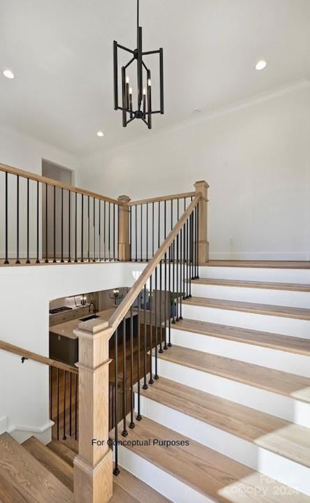 stairs featuring ornamental molding, a notable chandelier, and hardwood / wood-style flooring