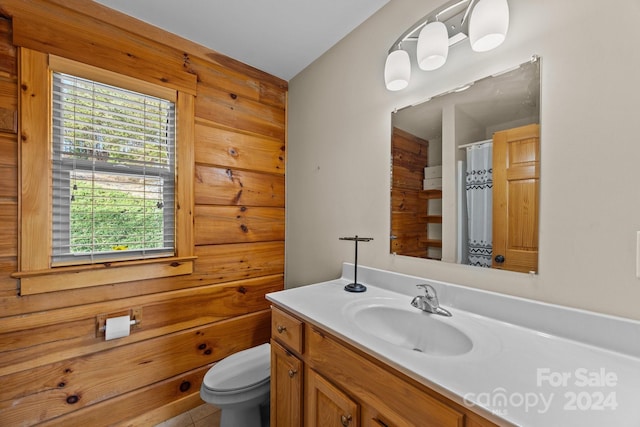 bathroom featuring tile patterned flooring, vanity, toilet, and walk in shower