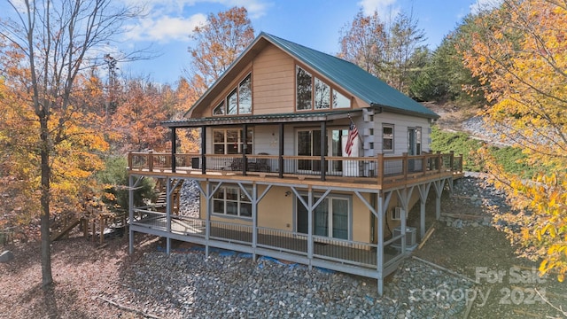 rear view of house with central AC unit and a deck