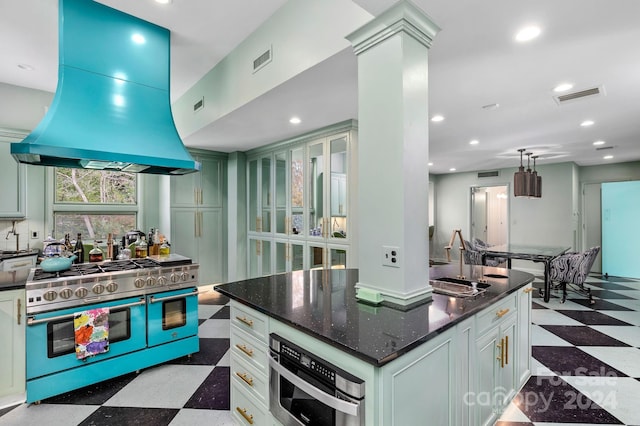 kitchen featuring island exhaust hood, appliances with stainless steel finishes, sink, a center island, and white cabinetry