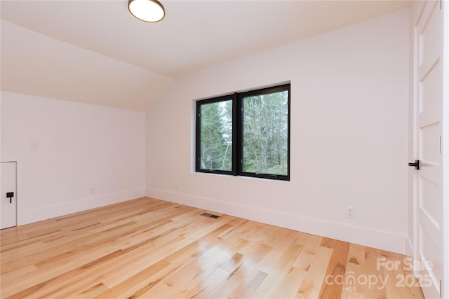 bonus room with hardwood / wood-style floors and vaulted ceiling