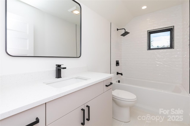 full bathroom with tiled shower / bath, vaulted ceiling, vanity, and toilet