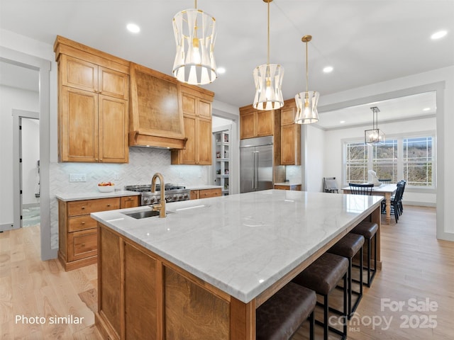 kitchen with built in fridge, pendant lighting, and a spacious island