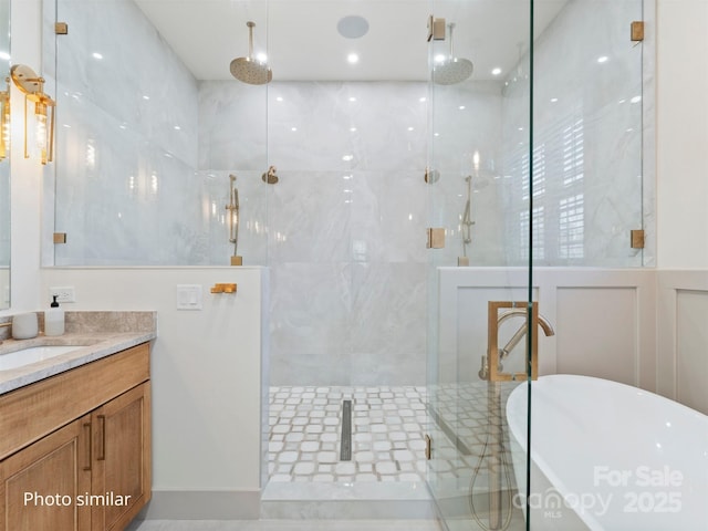 bathroom with a soaking tub, a shower stall, and vanity