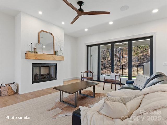 living room featuring ceiling fan, recessed lighting, a fireplace, and wood finished floors