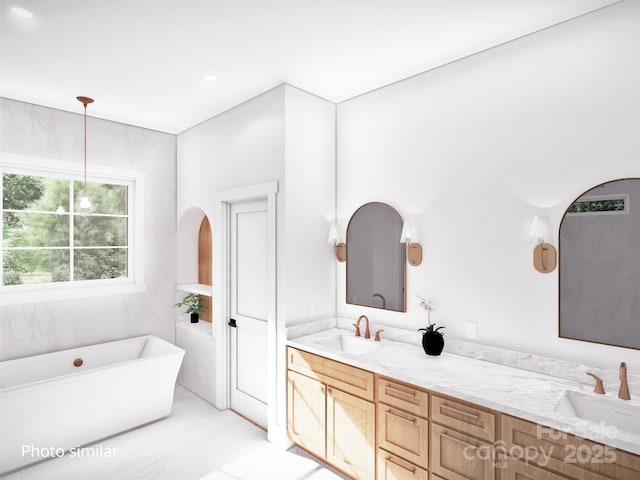 bathroom featuring a freestanding bath, double vanity, and a sink