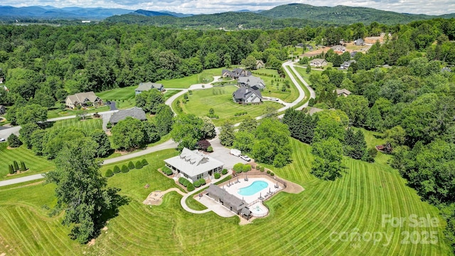 birds eye view of property with a mountain view and a wooded view