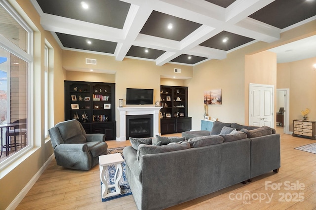 living room featuring beam ceiling, light hardwood / wood-style floors, and coffered ceiling