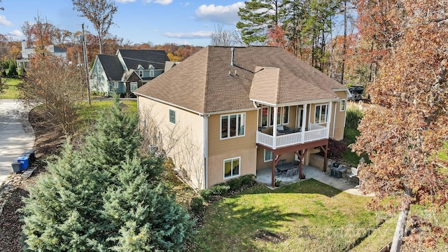 rear view of house featuring a patio area and a yard