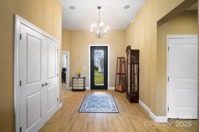 entrance foyer with an inviting chandelier and light hardwood / wood-style flooring