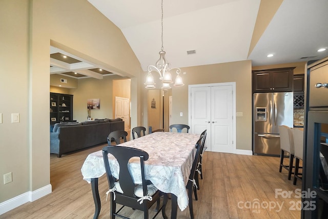 dining area featuring beamed ceiling, light wood-type flooring, a notable chandelier, and coffered ceiling