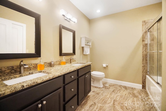 full bathroom with vanity, bath / shower combo with glass door, and toilet