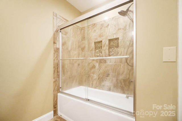 bathroom with combined bath / shower with glass door