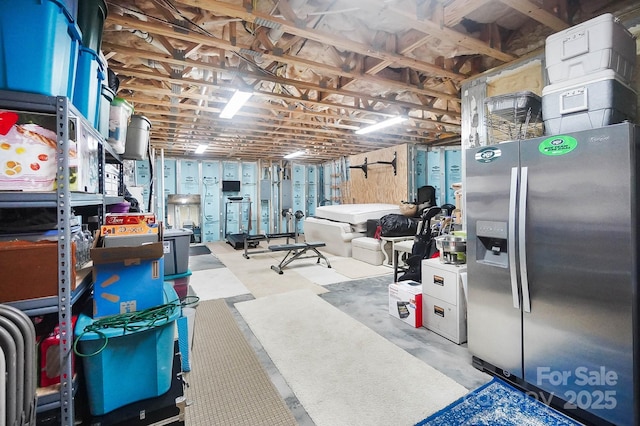 basement featuring stainless steel fridge with ice dispenser