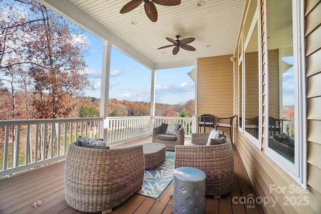 wooden terrace with ceiling fan and an outdoor living space