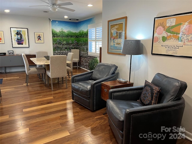 living room featuring wood-type flooring and ceiling fan