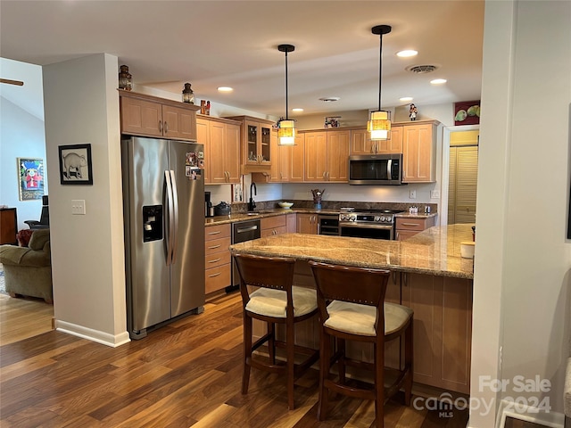 kitchen with sink, hanging light fixtures, dark hardwood / wood-style flooring, kitchen peninsula, and appliances with stainless steel finishes