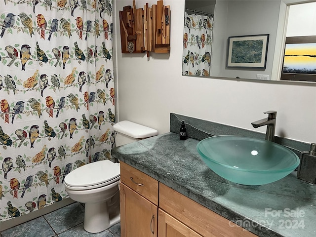 bathroom with tile patterned flooring, vanity, and toilet