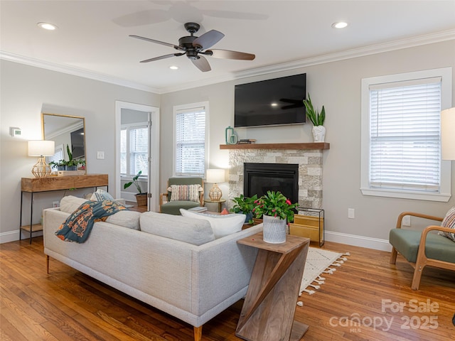 living room with a healthy amount of sunlight, ornamental molding, and wood-type flooring