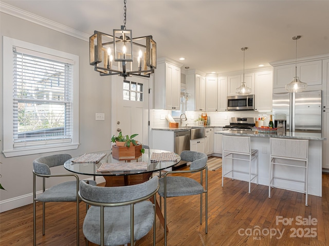 dining room featuring dark hardwood / wood-style flooring, crown molding, and a chandelier