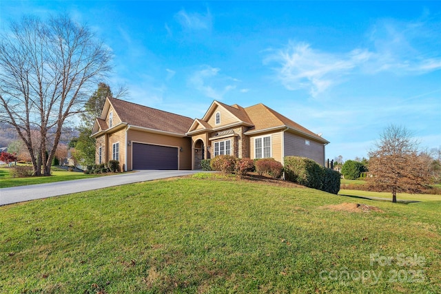 traditional-style home featuring driveway, stone siding, an attached garage, and a front yard