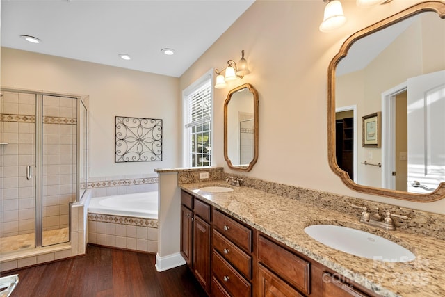 full bath featuring wood finished floors, a sink, a bath, and a shower stall